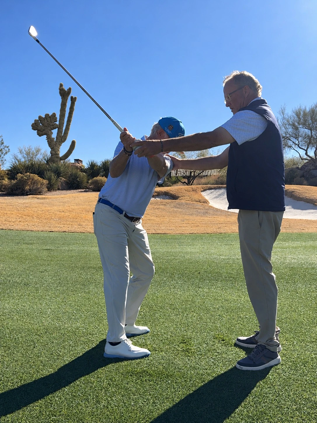 Hands-on golf coaching helping a golfer develop their swing